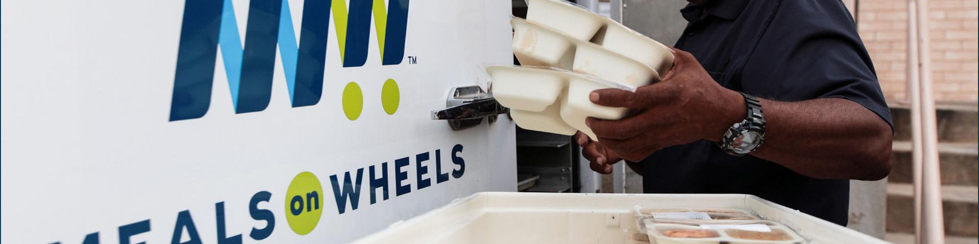 Man putting meals into a truck