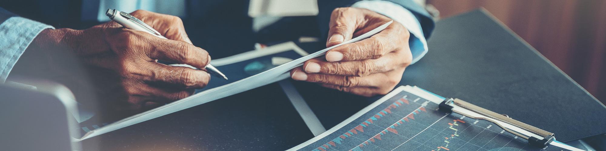 elderly man looking at stocks and graphs