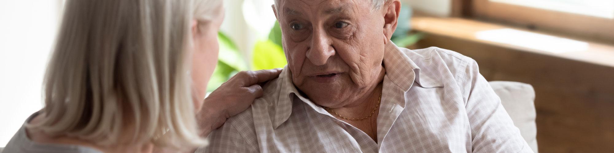 lady with her hand on the shoulder of an elderly man while he's talking