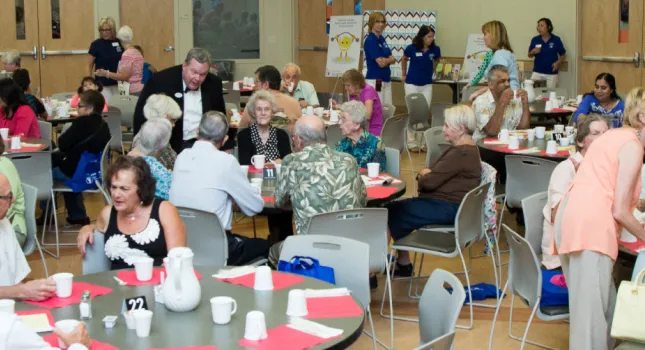 full cafe with seniors eating and talking