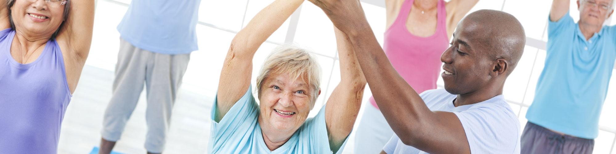 fitness coach helping a group of seniors exercise