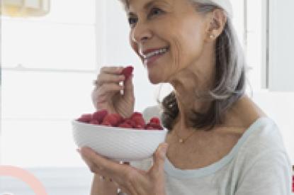 a senior lady smiling and eating healthy